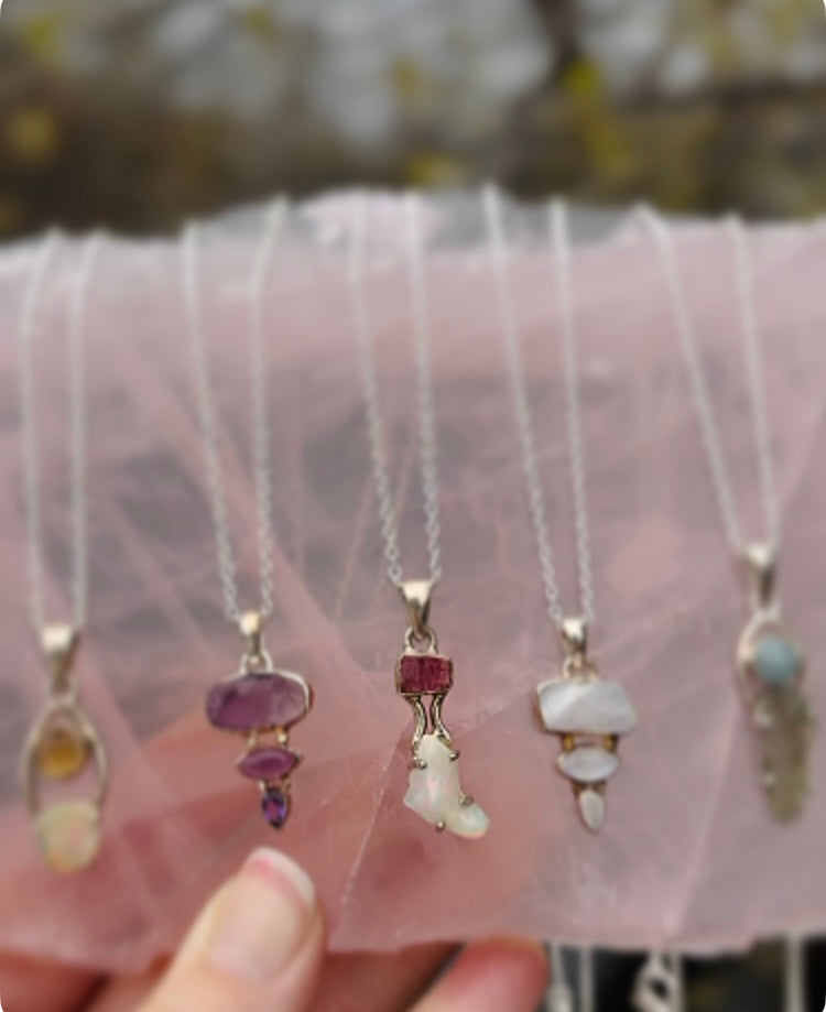 Close-up of pendant featuring Ethiopian Opal enhanced with crystal amplifier on delicate silver chain
