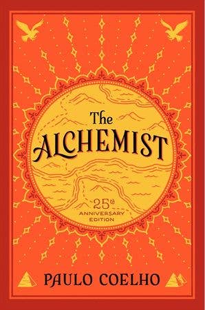 The Alchemist 25th Anniversary Edition book cover by Paulo Coelho with orange background and black and white illustrations
