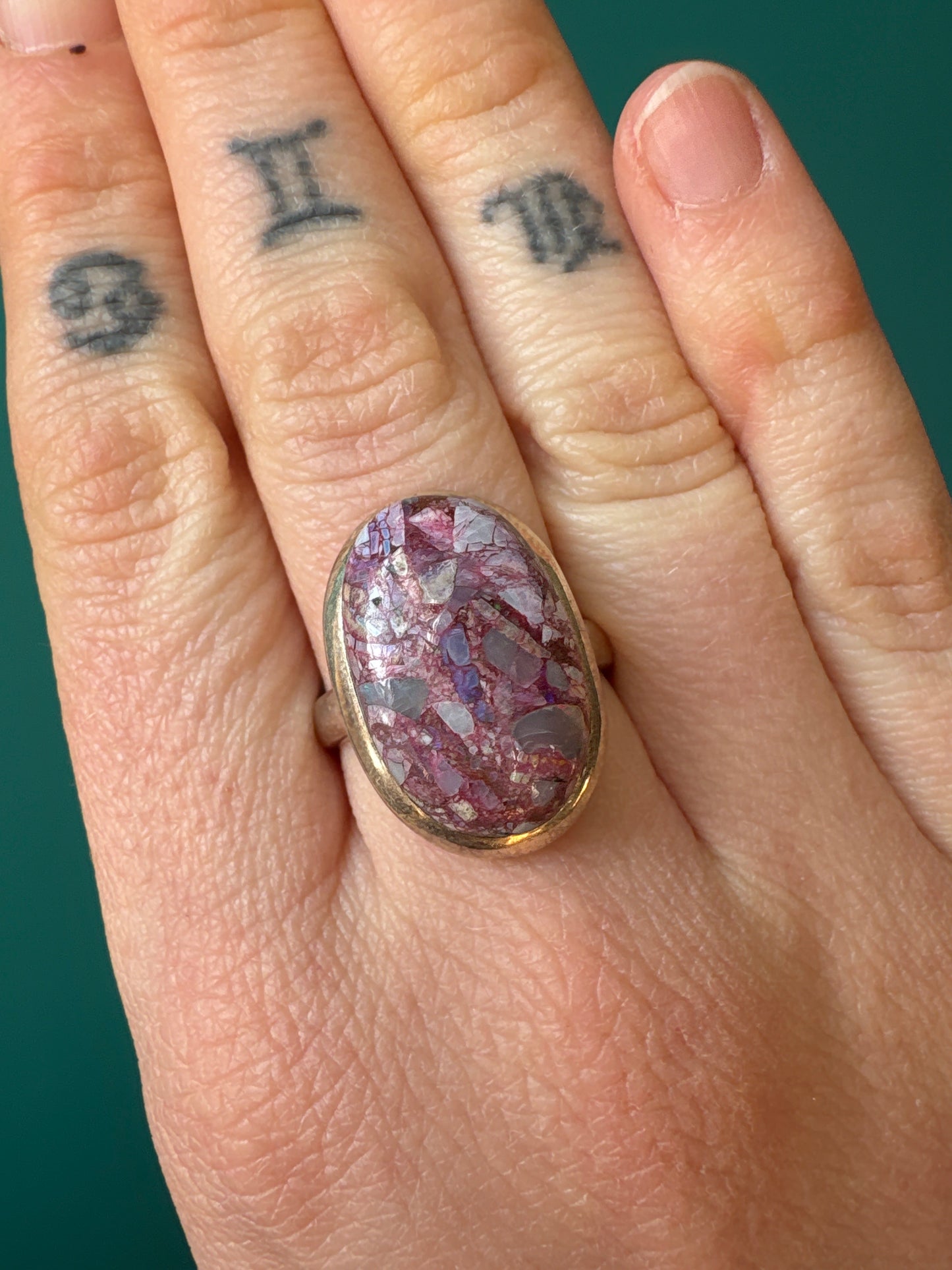 Ring Oyster Turquoise size 9 worn on finger showing oval purple gemstone with gold band