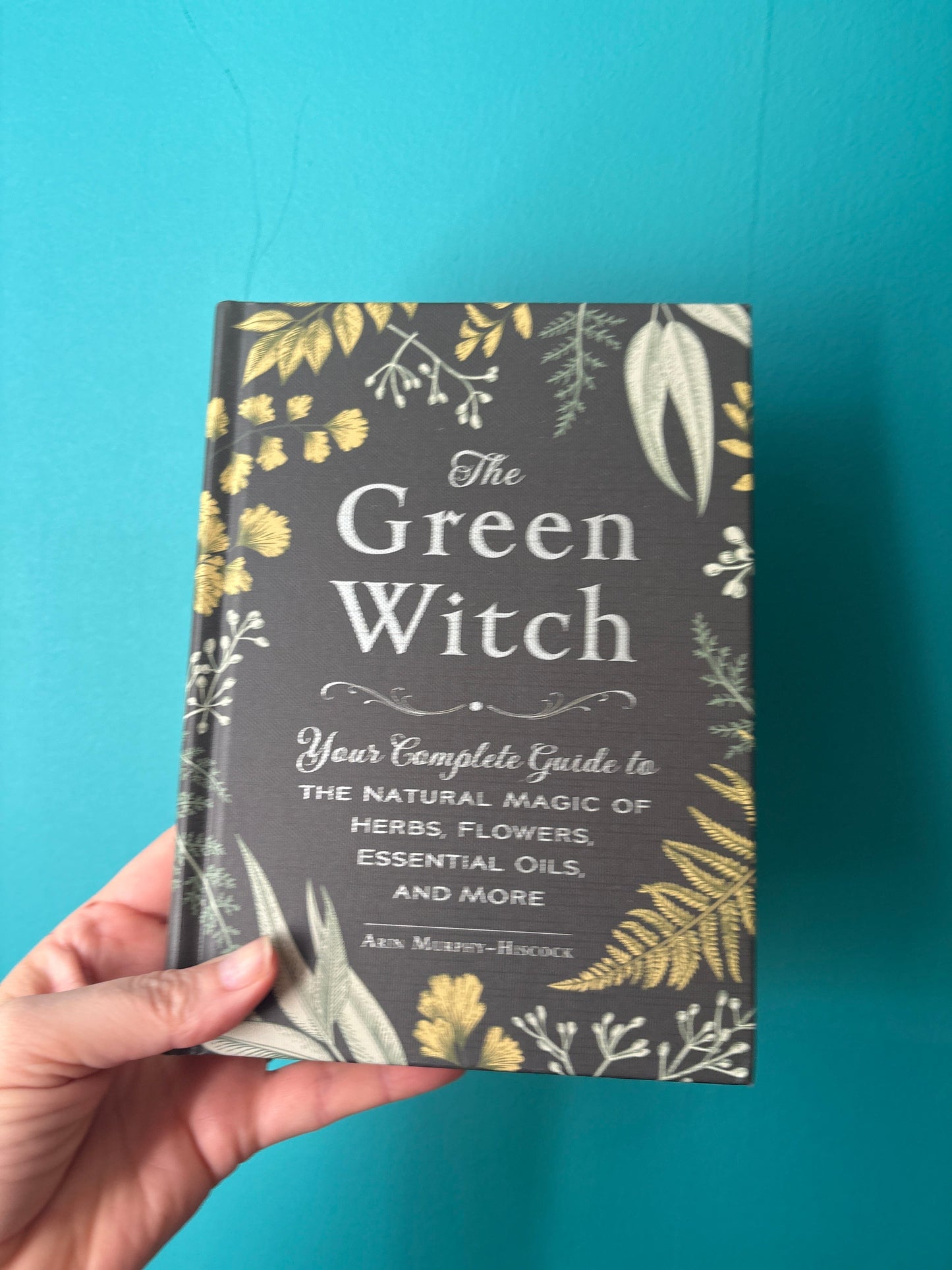 The Green Witch book cover with floral and herb illustrations on teal background