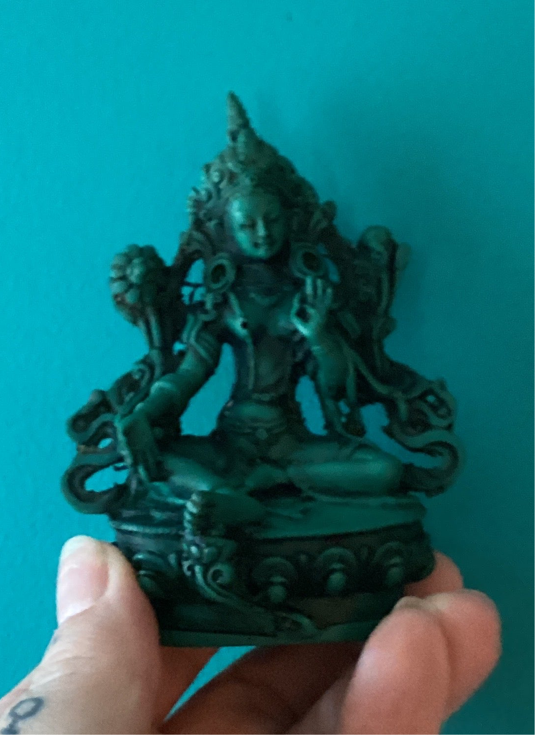 4.25 inch Green Tara Goddess statue figurine in intricate detail held against teal background