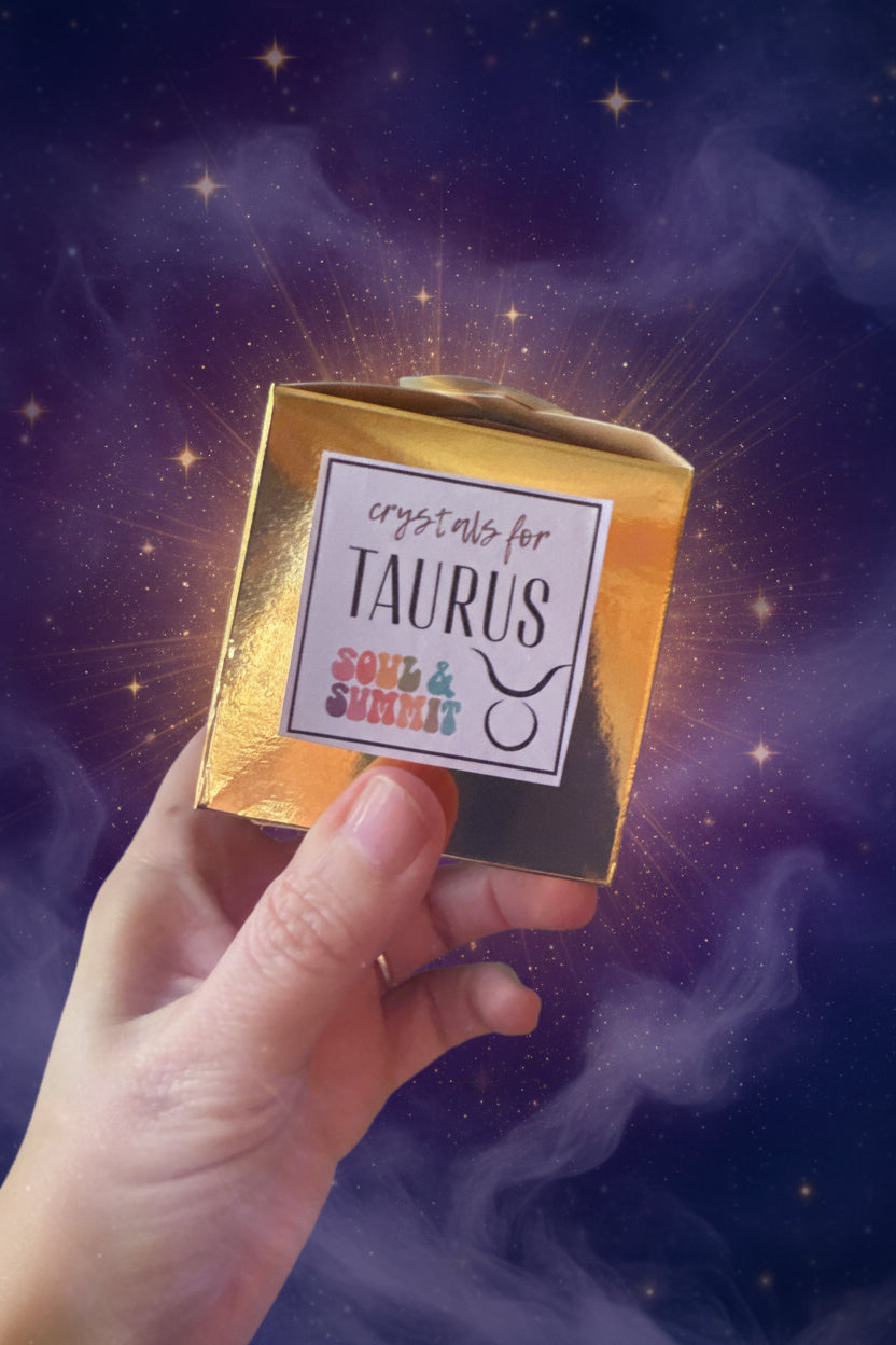 Taurus Crystal Box gold packaging held by hand with turquoise background