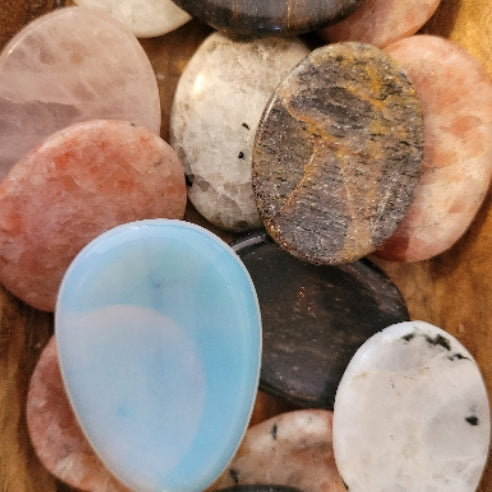 Assorted polished worry stones made from various calming crystals for stress relief and grounding