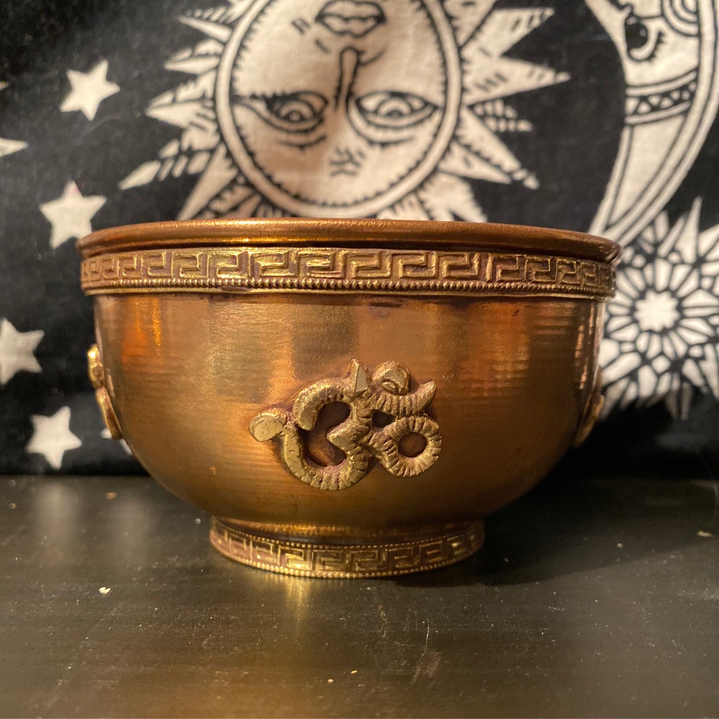 Copper Om Offering Bowl with intricate design and embossed Om symbol against a celestial background