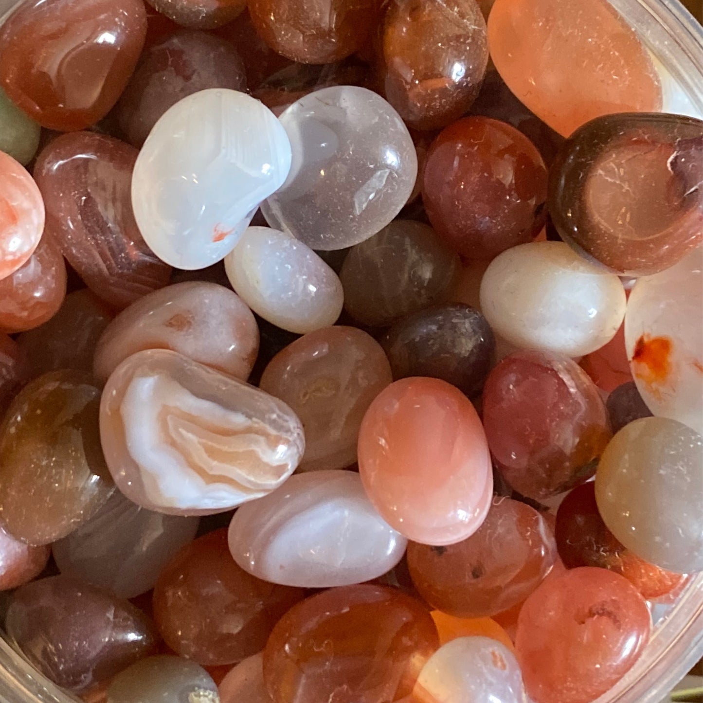 collection of polished mixed agate tumble stones featuring natural carnelian in various shades of orange, white, and brown