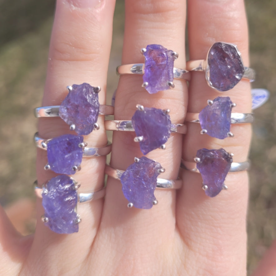 raw tanzanite rings with natural uncut blue-purple gemstones on silver bands displayed on fingers