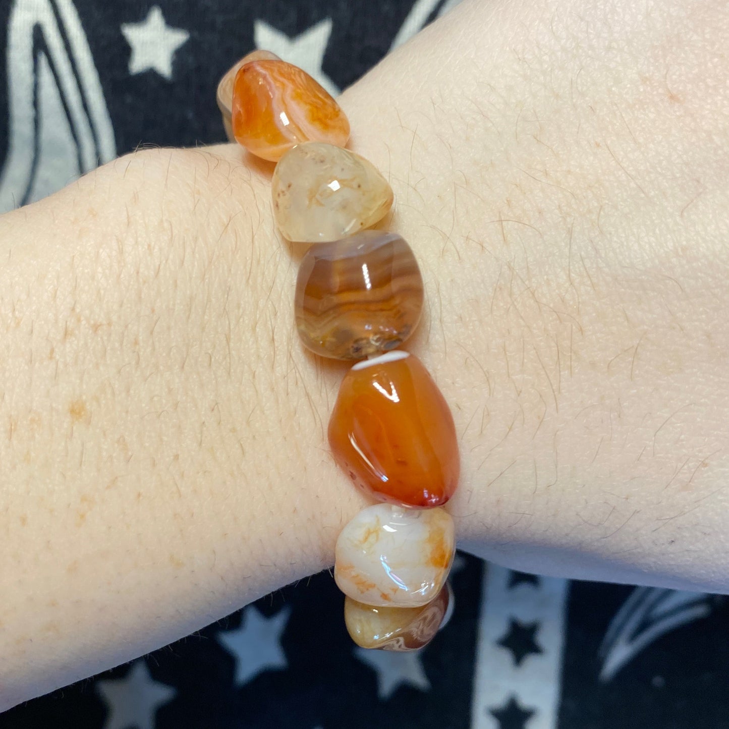 Carnelian tumbled bracelet with polished orange and brown stones on wrist
