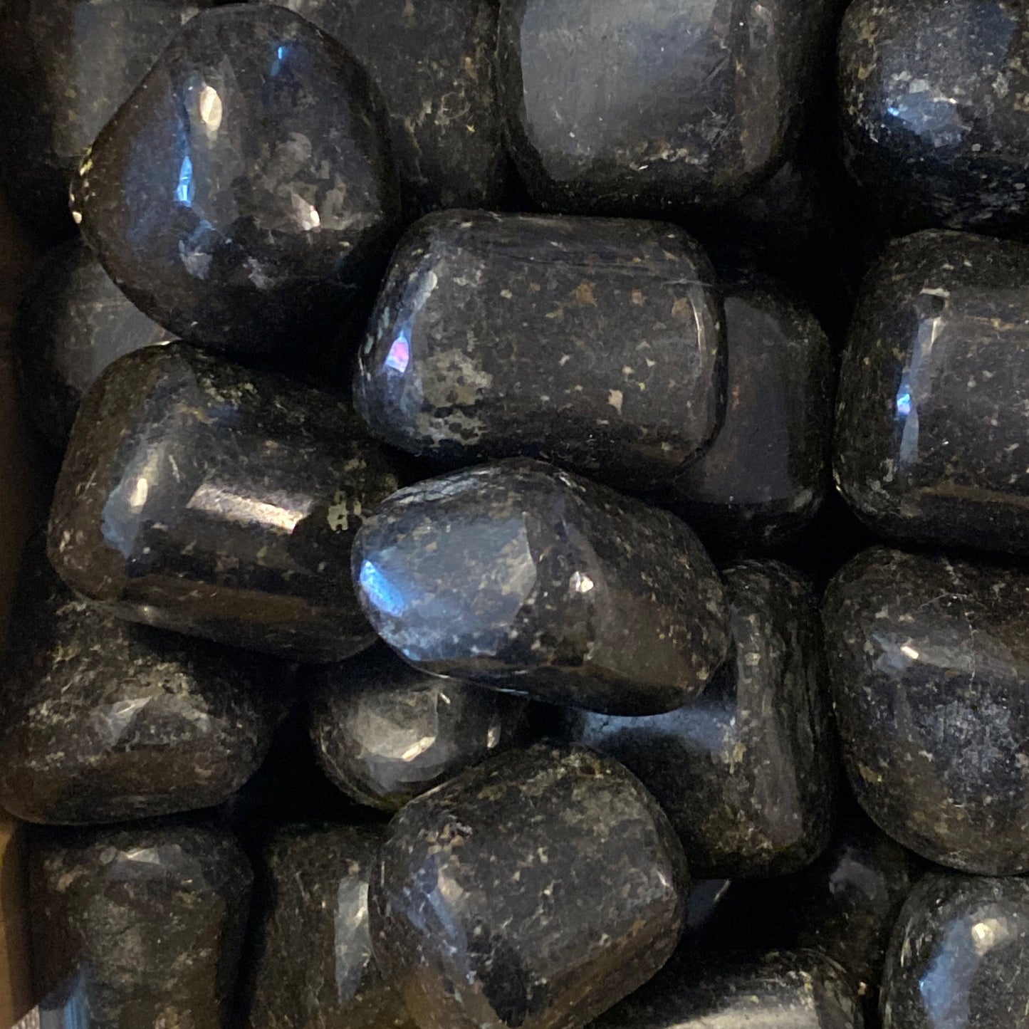 close-up of polished black Galaxy Jasper tumbles with galaxy-like patterns