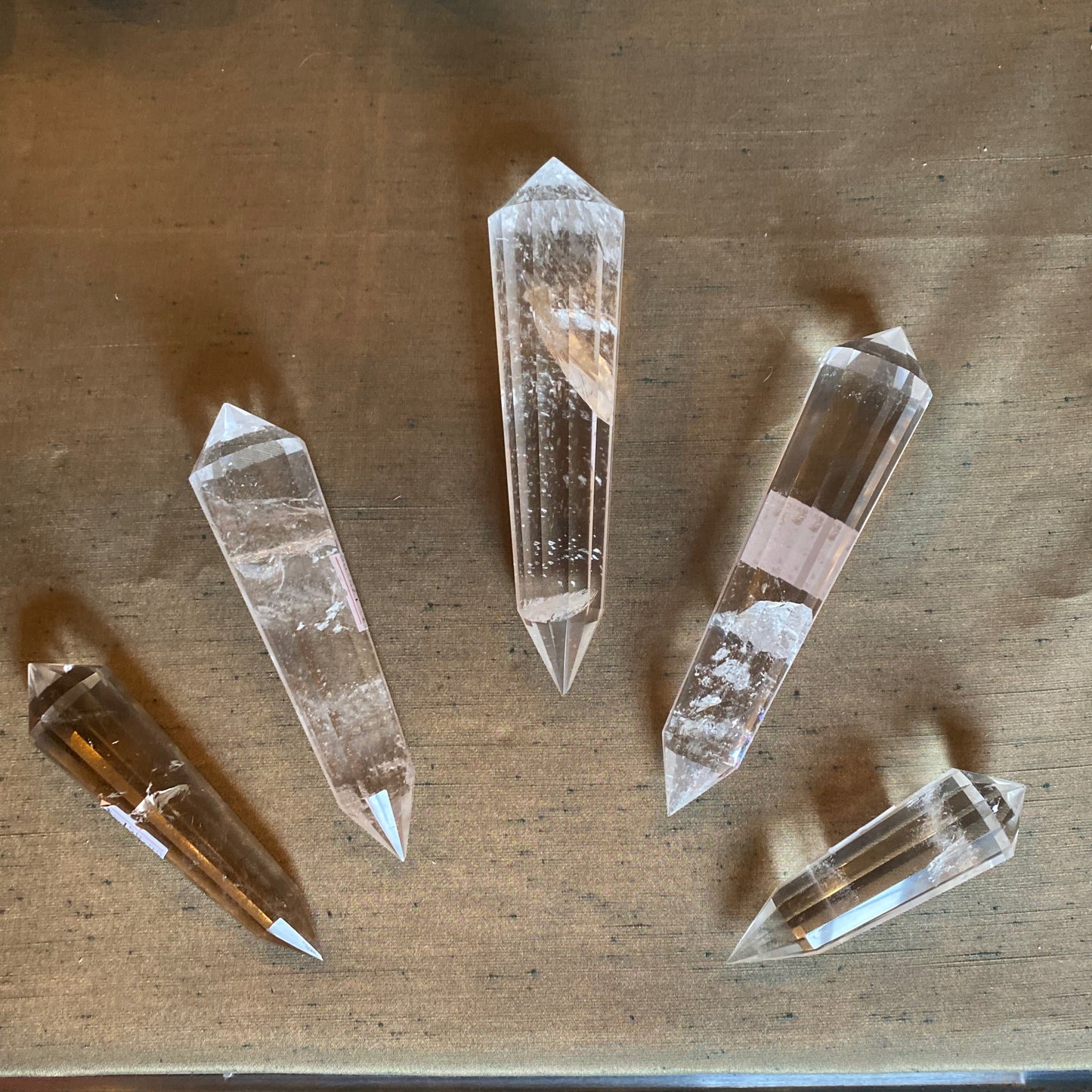 Set of five clear Crystal Vogel quartz points on a wooden surface