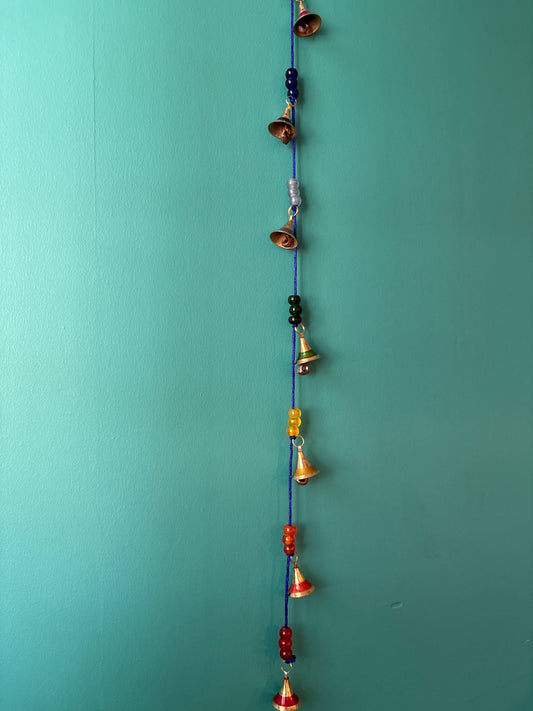 Handcrafted brass chakra bells strung on blue cord with colorful glass beads for meditation and mindfulness practice