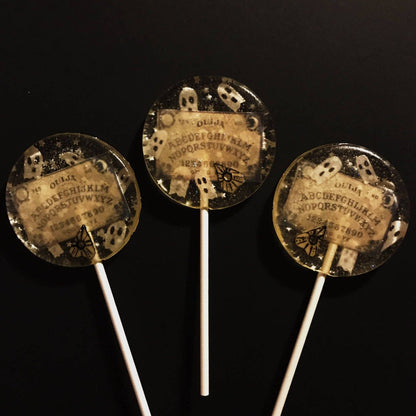 Wafer Paper Spooky Ouija Board Lollipops with ghost designs, edible silver stars, and glitter on clear candy sticks