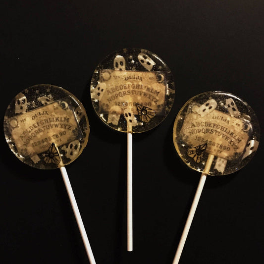 Wafer Paper Spooky Ouija Board Lollipops with ghost designs, edible silver stars, and glitter on clear candy sticks