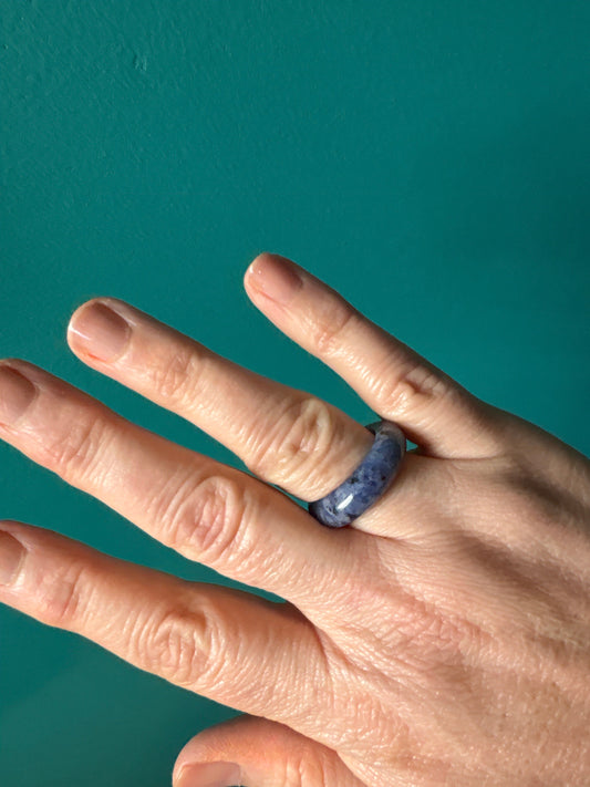 Minimalist sodalite ring on finger with calming blue stone design