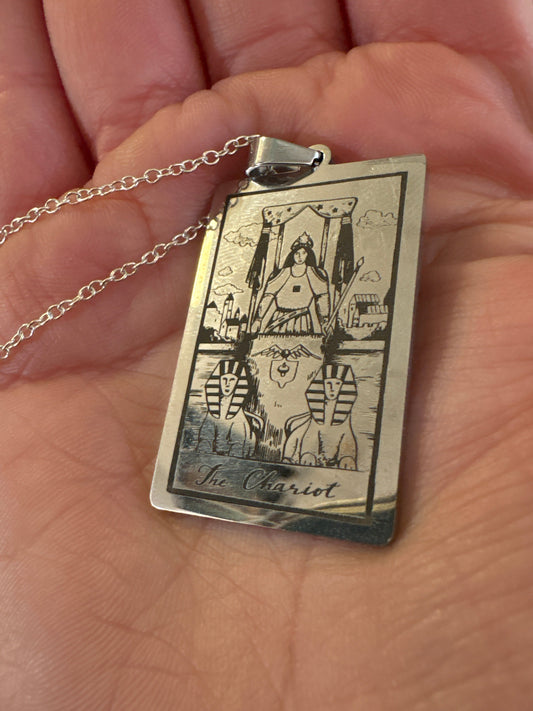 Necklace Chariot pendant with ancient chariot design on a silver chain held in hand