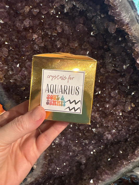 Aquarius Crystal gift box held over amethyst geode background