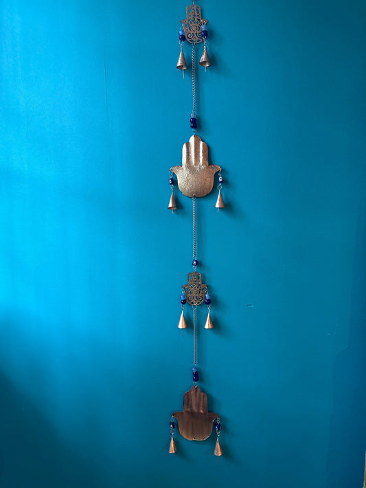 Decorative hanging bells with Fatima hands wall hanging on blue background