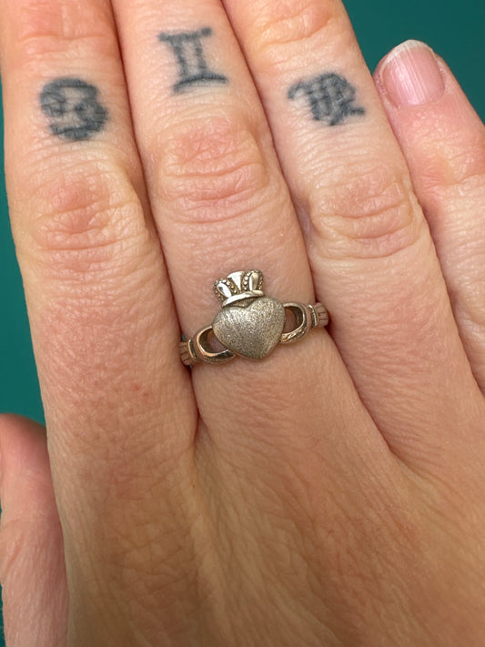 Ring Claddagh Adjustable silver ring featuring heart, crown, and hands design worn on finger