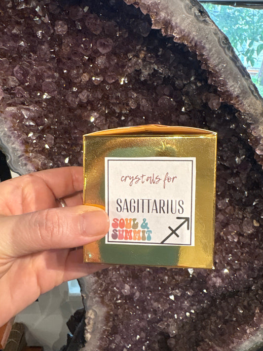 Sagittarius Crystal Gift Box held in hand with amethyst geode background