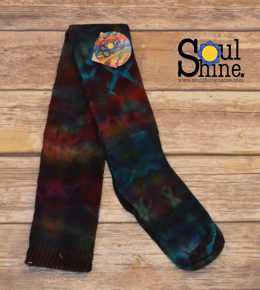 Bold rainbow tie dye thigh high cotton socks laid flat on wooden background