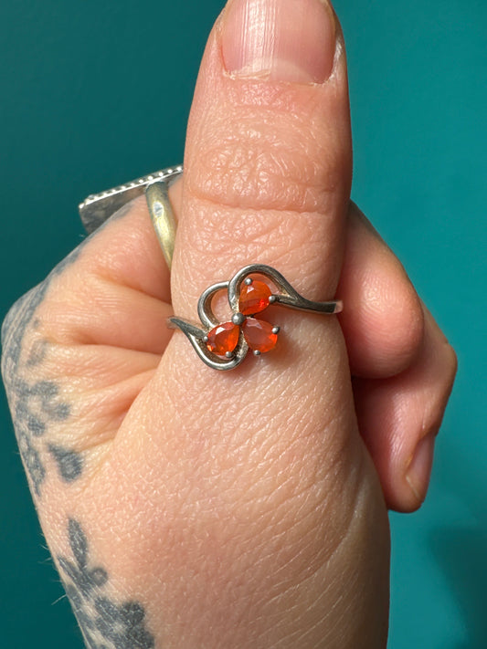 Silver ring with clover design featuring three Mexican fire opal stones on finger