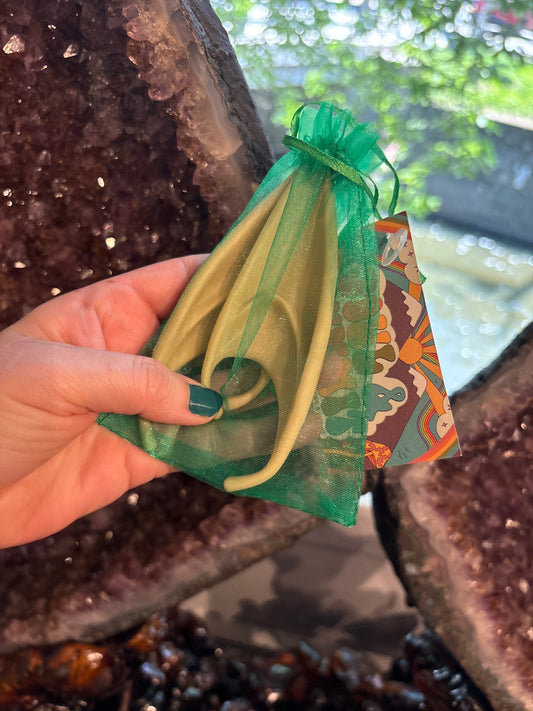 Green elf ears costume accessory in a green mesh pouch held by hand