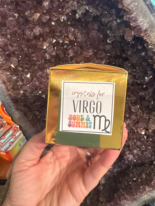 Virgo Crystal gift box held in hand with amethyst crystal background and Virgo zodiac symbol on the packaging