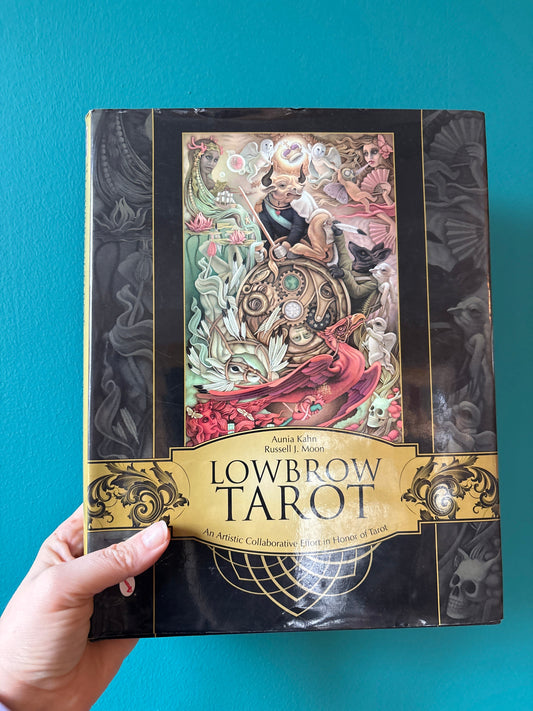 Lowbrow Tarot Book with modern artistic tarot card illustrations and interpretations against blue background
