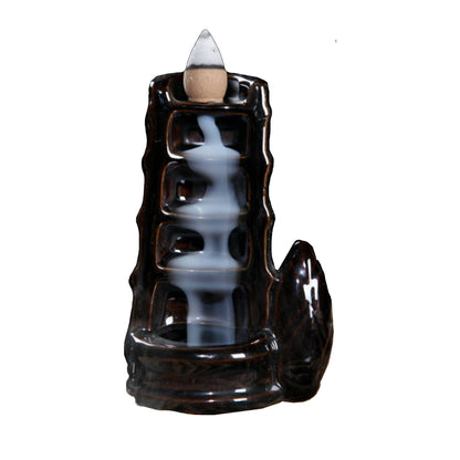 Ceramic backflow incense burner with tower waterfall design releasing smoke cascading down steps