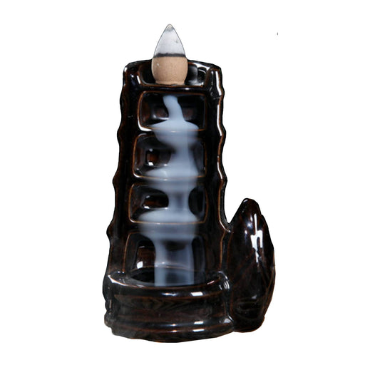 Ceramic backflow incense burner with tower waterfall design releasing smoke cascading down steps