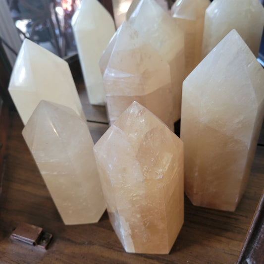 Honey calcite points tower crystals on wooden surface
