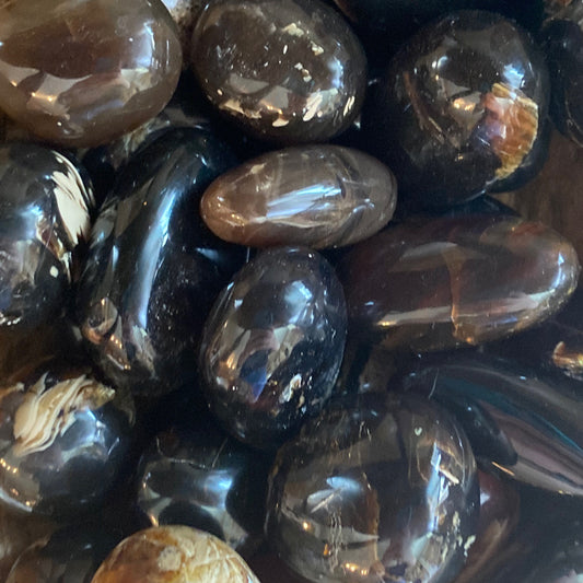Polished amber tumble stones with natural brown hues and calming properties for wellness and self-care.