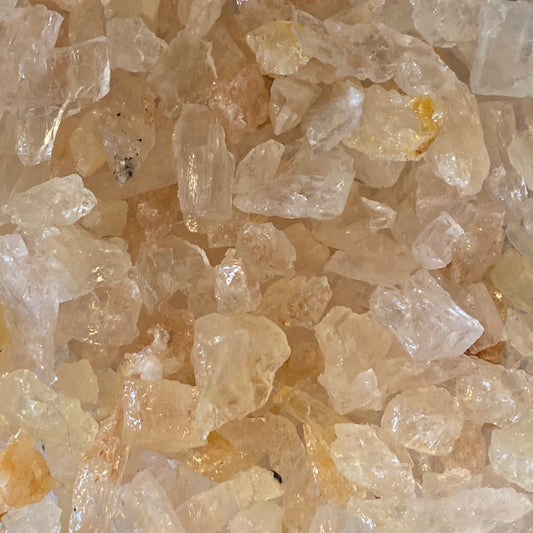 Close-up of raw Morganite tumbles in shades of pink and peach, showcasing their natural luster and texture.