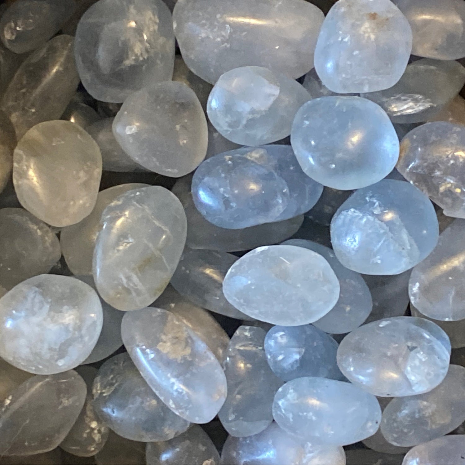 smooth polished celestite tumble stones with translucent light blue and white hues for calming energy and meditation