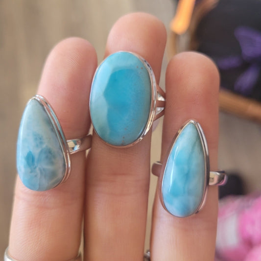 Hand wearing three silver Ring Larimar with blue oval and teardrop stones