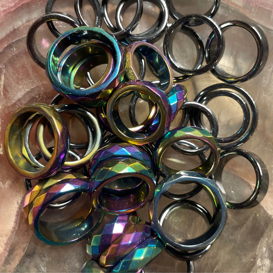 Collection of polished and faceted hematite rings in black and iridescent colors for stress relief and well-being