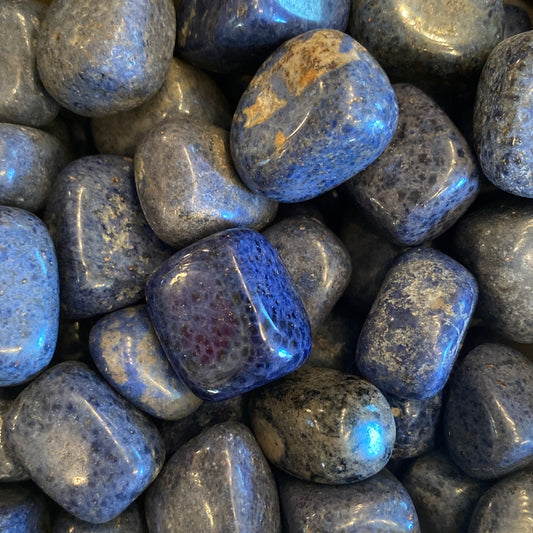 Close-up of polished blue dumortierite tumble stones with glossy finish