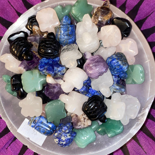 Assorted mini crystal turtle pendants in various colors displayed in a bowl