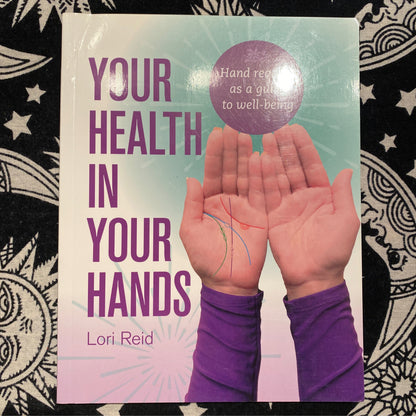Book cover showing a pair of hands with palm lines and the title Your Health In Your Hands by Lori Reid focusing on health and well-being