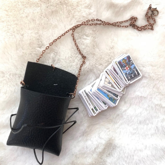 Mini Tarot Pouch Necklace with black leather pouch and tiny tarot cards on a copper chain against a soft white background