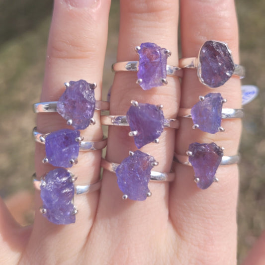 raw tanzanite rings with natural uncut blue-purple gemstones on silver bands displayed on fingers