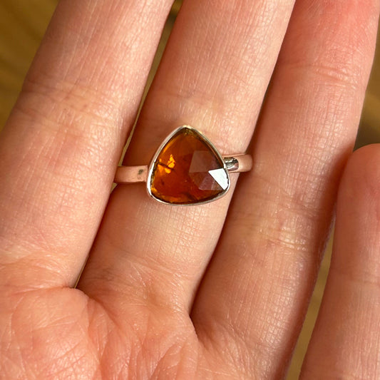 Ring Orange Kyanite with faceted triangular orange stone set in silver band on finger