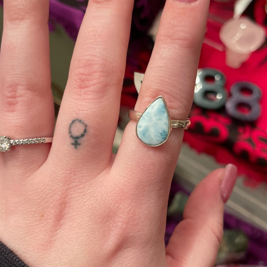 Adjustable teardrop larimar ring on finger showcasing natural blue gemstone and silver band