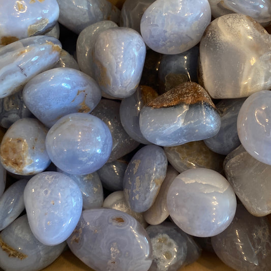Smooth polished tumbled blue chalcedony stones with calming blue hues and unique natural patterns