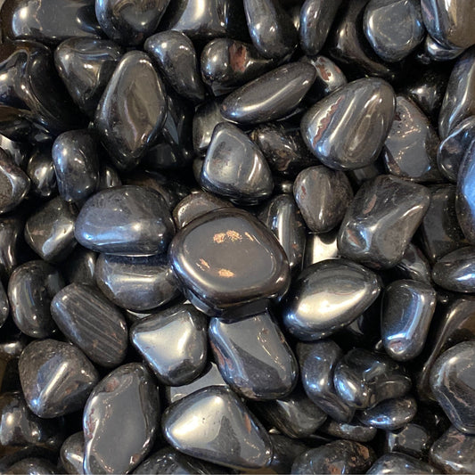 Smooth polished hematite tumble stones promoting mental clarity and grounding balance