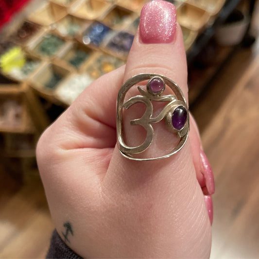 Adjustable sterling silver ring with Amethyst stones forming an Om symbol on finger