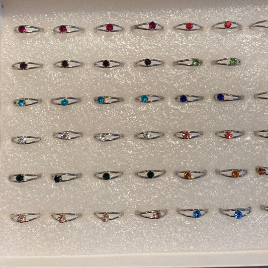 Collection of adjustable birth stone rings with various colored gemstones displayed in rows