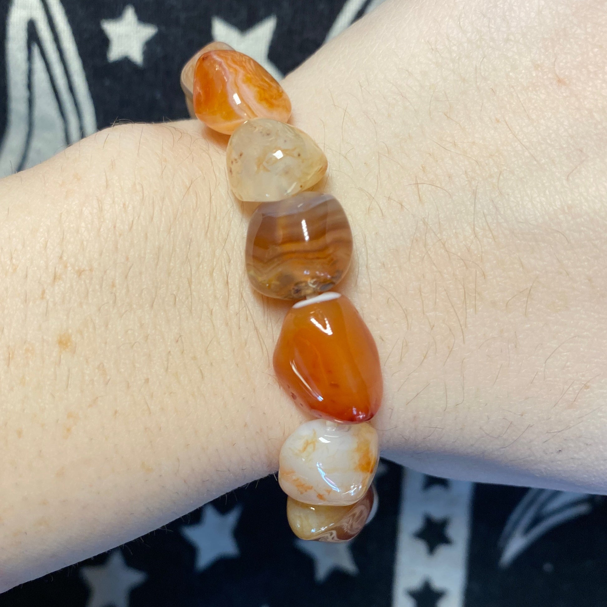 Carnelian tumbled bracelet with polished orange and brown stones on wrist