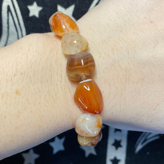 Carnelian tumbled bracelet with polished orange and brown stones on wrist
