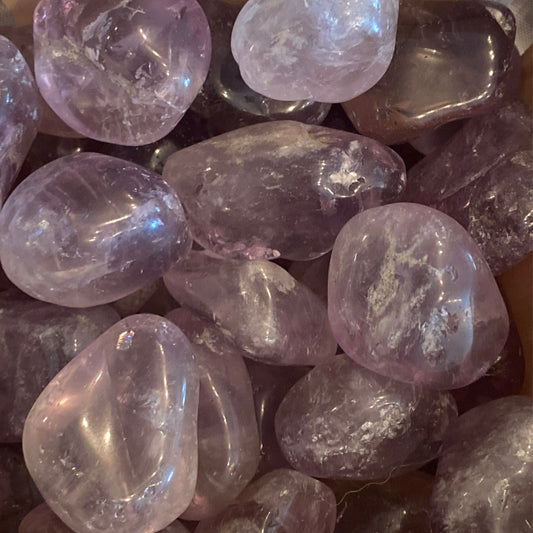 Close-up of polished amethyst tumble stones with a calming purple hue for relaxation and healing benefits