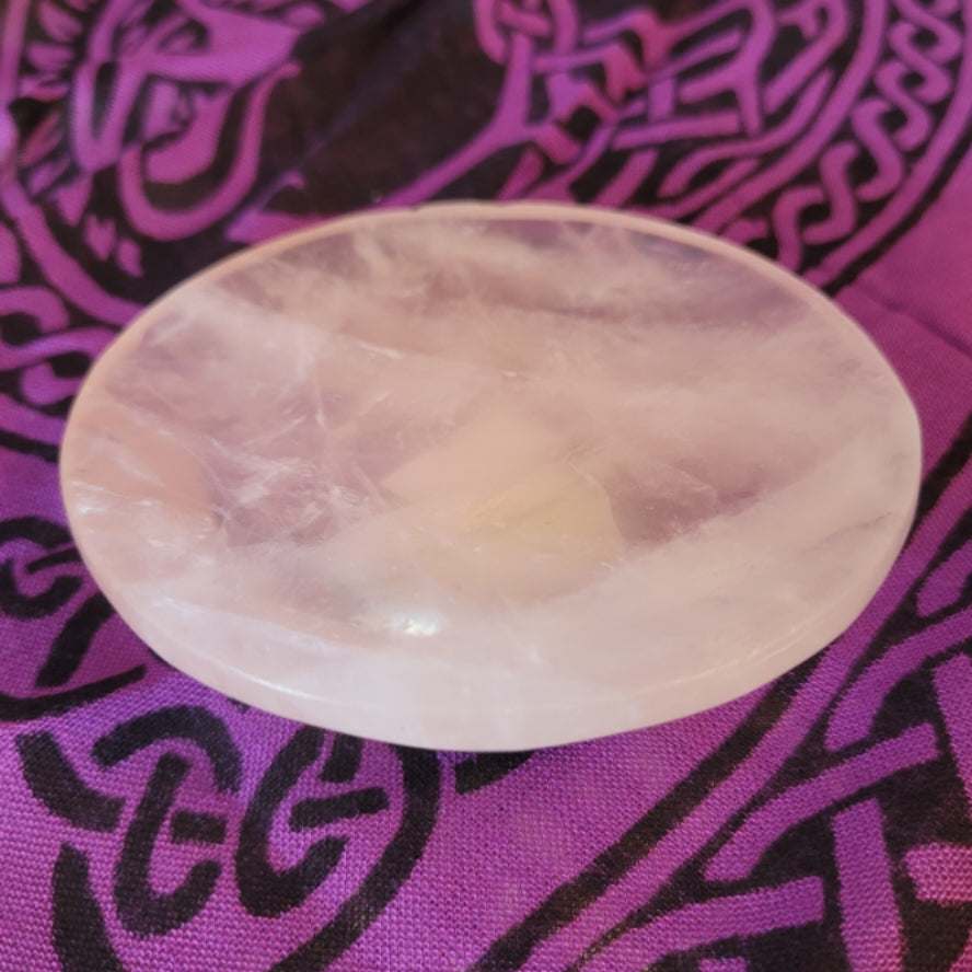 Rose quartz bowl dish on purple patterned fabric background